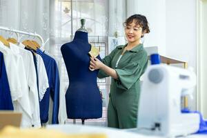 elegante freelance costureira é prendendo dela marcação colarinho para Novo vestir de prendendo para manequim enquanto trabalhando dentro dela artístico oficina estúdio para moda Projeto e roupas o negócio indústria foto