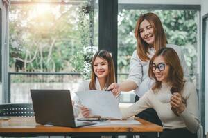 sorridente diverso empregados colegas ter Diversão rir colaborar chuva de ideias em computador às escritório equipe reunião. feliz multiétnico pessoas de negócio trabalhos juntos em computador portátil discutir o negócio Ideias dentro grupo. foto