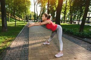 lindo atleta mulher fazendo ginástica exercício fora. apreciar esporte e manter seu corpo ajustar. esporte, fitness, saudável ativo estilo de vida conceito foto