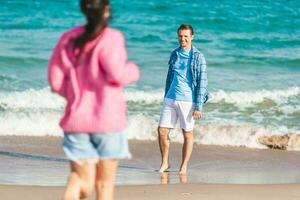 jovem casal apaixonado nas férias de verão na praia. homem e mulher felizes aproveitam o tempo juntos foto