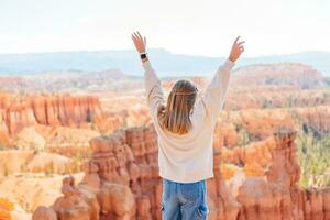 pequeno menina dentro Bryce desfiladeiro caminhada relaxante olhando às surpreendente Visão durante caminhar em verão viagem dentro Bryce desfiladeiro nacional parque, utah, Unidos estados. foto