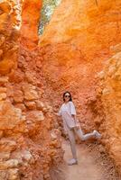 caminhante mulher dentro Bryce desfiladeiro caminhada relaxante olhando às surpreendente Visão durante caminhar em verão viagem dentro Bryce desfiladeiro nacional parque, utah, Unidos estados. foto