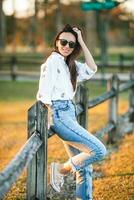 retrato do feliz jovem mulher ao ar livre dentro a parque às pôr do sol foto