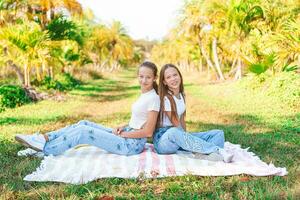 dois meninas dentro jeans dentro uma campo com Palma árvores foto