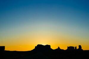 Visão do monumento vale dentro Utah dentro luar. pôr do sol às monumento vale com lua em a céu foto