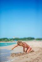 adorável menina brincando com brinquedos de praia durante as férias tropicais foto