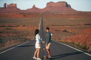 feliz casal em a famoso estrada para monumento vale dentro utah. surpreendente Visão do a monumento vale. foto