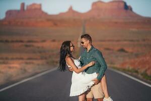 feliz casal em a famoso estrada para monumento vale dentro utah. surpreendente Visão do a monumento vale. foto