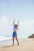 jovem mulher feliz na praia aproveite o vento foto