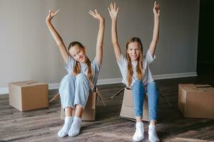lindas garotas se mudando para uma nova casa com caixas de papelão foto