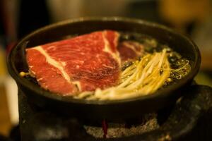 cozinhando cru carne e dourado agulha cogumelo em grelhado carne em quente panela foto