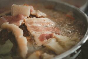 carne de porco em uma quente prato ou Mookata. moo ka ta a alumínio cúpula grade de carvão às a topo do a recipiente você pode grade muitos coisas foto