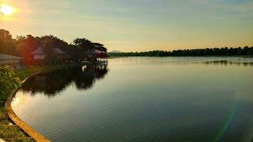 pôr do sol dentro bueng chawak lago dentro suhaburi província, tailândia, em meio a dormindo árvores foto