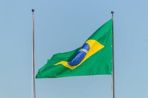 bandeira brasileira hasteada com fundo de céu azul