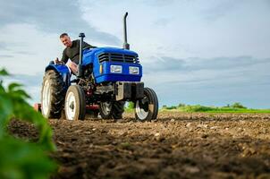 uma agricultor em uma trator trabalho a campo. moagem solo, esmagamento e afrouxamento terra antes corte linhas. terra cultivo. agricultura, agricultura. preparatório terraplenagem antes plantio uma Novo cortar. foto