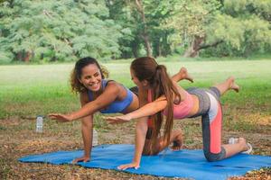 mulheres de fitness praticando ioga em um parque. mulheres fazendo exercícios de fitness em um parque. foto