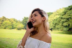 retrato de uma linda mulher sorridente, enviando mensagens de texto e falando com o telefone