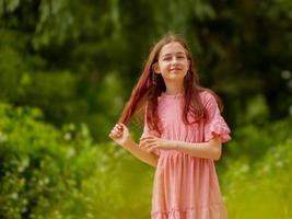 retrato de uma menina em um vestido rosa no parque foto