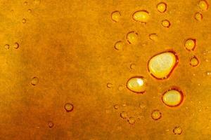 textura de cera de cannabis dourada, fundo macro de salpicos de maconha foto