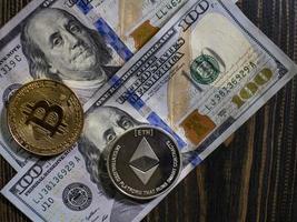 bitcoin e ethereum em notas de cem dólares em uma madeira