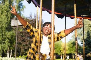 uma mulher afro-americana feliz no parque de diversões foto
