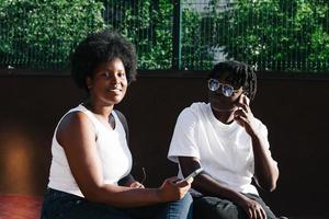 duas mulheres afro-americanas felizes se comunicam e riem na rua