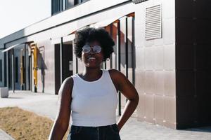 mulher afro-americana feliz caminha pela rua no verão foto