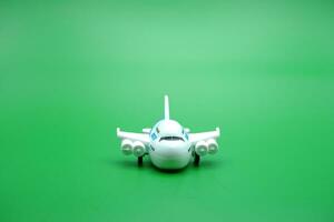 mini avião brinquedo isolado verde fundo. branco e azul avião brinquedo. foto