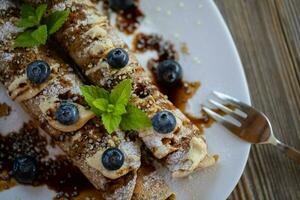 uma prato coberto com crepes e amoras foto