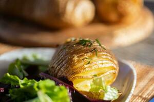 cozido Jaqueta batatas com mergulhar, misturado verde salada folhas e cânhamo óleo foto