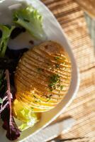 cozido Jaqueta batatas com mergulhar, misturado verde salada folhas e cânhamo óleo foto