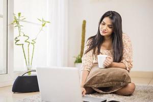 linda jovem indiana usando laptop em casa foto