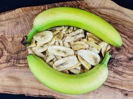 lascas de banana secas em madeira de oliveira foto