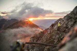 Áustria, Tirol, Innsbruck, alpinista às Nordkette através da ferrata às nascer do sol foto