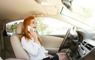 feliz o negócio mulher usando dela Smartphone dentro uma carro foto