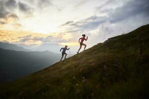 homem e mulher corrida morro acima dentro a montanhas foto