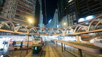 iluminado rua do hong kong com trilhos e pedestre ponte foto