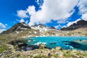 pequeno lago alpino colorido com o último gelo foto