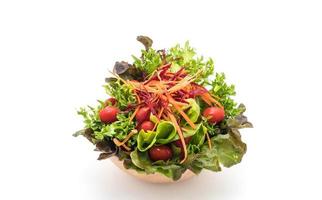 Salada mista em tigela de madeira no fundo branco foto