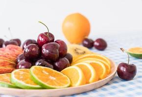 Misto de frutas fatiadas em tigela de madeira foto