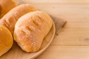 pão em prato de madeira sobre a mesa foto