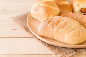 pão em prato de madeira sobre a mesa foto