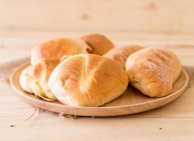 pão em prato de madeira sobre a mesa foto