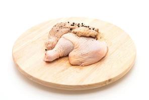 Coxa de frango marinado com molho, pimenta preta, alho e pimenta seca na tábua de madeira