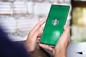 chiang mai, tailândia 2021- mulher segurando smartphone com o aplicativo Starbucks na tela foto