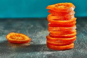 fatias de laranjas ou tangerinas secas em um fundo azul foto