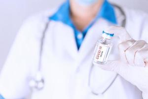 médico segurando a vacina covid-19 para tratamento e cura