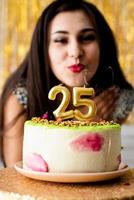Mulher caucasiana em vestido de festa preto pronta para comer bolo de aniversário foto