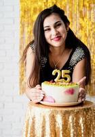 mulher com vestido de festa preto pronta para comer bolo de aniversário foto