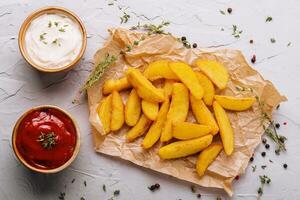 cozido frito batatas com vermelho e branco molhos foto